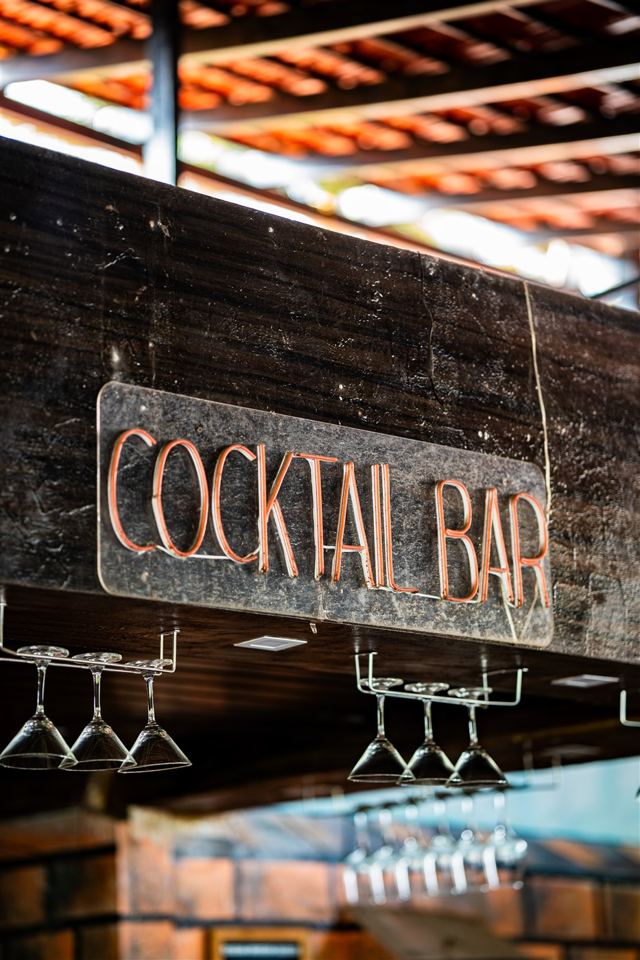 Cocktail bar sign above glass rack
